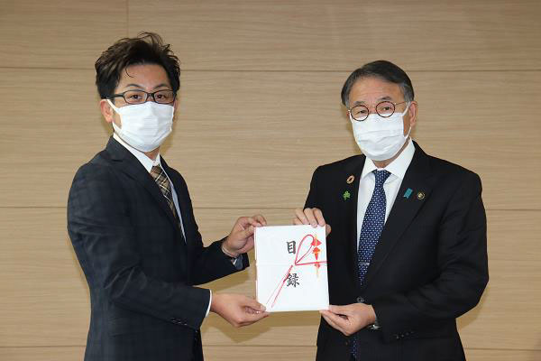 臂泰雄市長(右側)へ目録を手渡す全日本オートレース選手会伊勢崎支部の猿谷支部長